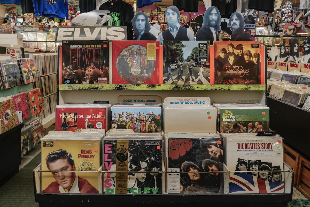 Eine spezielle Abteilung in einem Plattenladen, in der Alben und Erinnerungsstücke von Elvis Presley ausgestellt sind, der großen Rocklegende, die für ihre einflussreiche Musik und ihre charismatischen Auftritte bekannt ist.